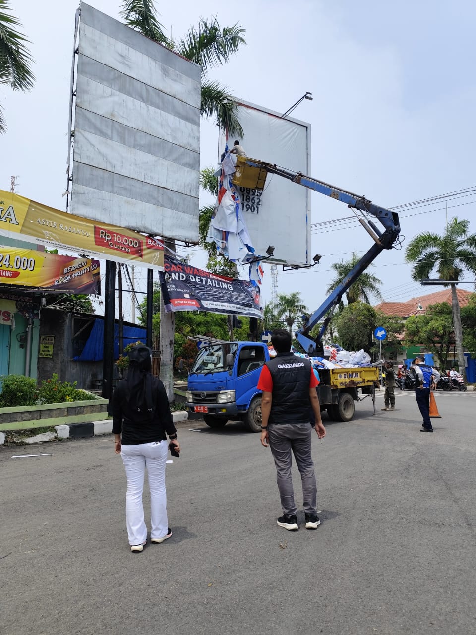 Anggota Bawaslu Kabupaten Rembang, Nibrosu Rohid dan Komisioner KPU Rembang, Maskutin, saat menyaksikan penertiban APK, pada Minggu (24/11)